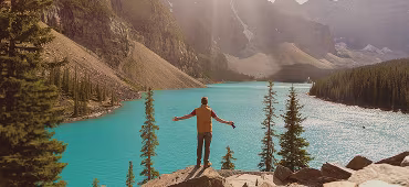 Traveler by a turquoise lake in the mountains
